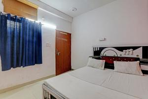 a bedroom with a bed and a blue curtain at OYO Hotel Surya Palace in Kushinagar