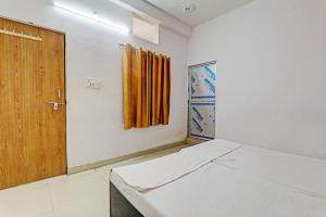 Habitación con cama y puerta de madera en OYO Hotel Surya Palace, en Kushinagar