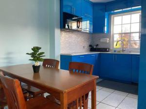 a kitchen with blue cabinets and a wooden table with a potted plant at Remodeled & Very Cozy sleeps 12 near Casa Bacardi, Center Unit in Catano +7 photos