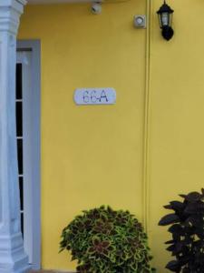 a sign on the side of a yellow wall at Remodeled & Very Cozy sleeps 12 near Casa Bacardi, Center Unit in Catano