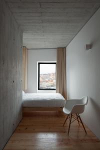 een slaapkamer met een bed en een stoel voor een raam bij Oh! Porto - Whole Property in Vila Nova de Gaia