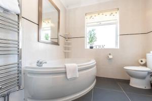 een witte badkamer met een bad en een toilet bij Douglas House in Southampton