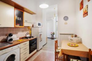 a kitchen with a table and a stove top oven at Casa vacanza Teresita 300mt Mare in Imperia