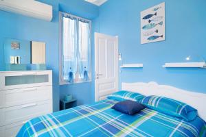a blue bedroom with a bed with blue walls at Casa vacanza Teresita 300mt Mare in Imperia