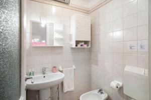 a white bathroom with a sink and a toilet at Casa vacanza Teresita 300mt Mare in Imperia +27 photos
