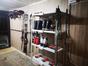 une chambre avec skis et matériel de ski sur les étagères dans l'établissement Гостевой дом Discovery, à Almaty