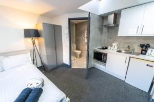 a room with a bed and a sink and a kitchen at Captivating 1-Bed studio in Birmingham in Birmingham