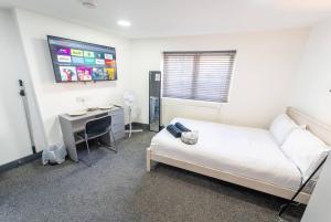 - une chambre avec un lit, un bureau et un ordinateur dans l'établissement Captivating 1-Bed studio in Birmingham, à Birmingham