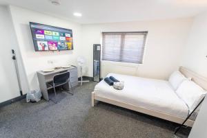 a bedroom with a bed and a desk and a computer at Captivating 1-Bed studio in Birmingham in Birmingham