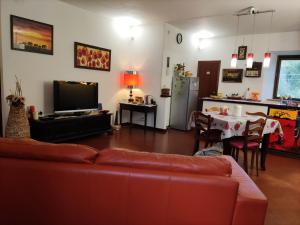 卡梅利諾的住宿－La Casa di Elena，一间带红色沙发的客厅和一间厨房