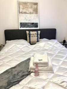 a bed with towels and a pink bottle on it at Cosy Apartment nearly City Hall Vienna and Subway in Vienna