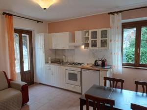 a kitchen with white cabinets and a table and a dining room at Villa Celeste in Rocca Pia