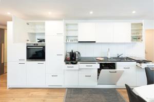 una cocina blanca con armarios y electrodomésticos blancos en Exklusive 2,5 Zimmer Wohnung en Eschenz
