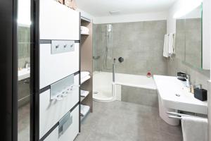 埃申茨Exklusive 2,5 Zimmer Wohnung的带水槽、浴缸和马桶的浴室