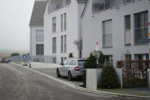 um carro prateado estacionado ao lado de um edifício branco em Exklusive 2,5 Zimmer Wohnung em Eschenz