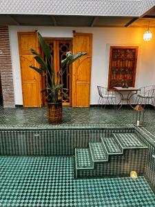 a group of green benches sitting in a courtyard at Riad Darchica in Marrakech