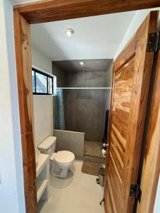 ein Bad mit einem WC und einer Dusche in der Unterkunft Stella Mar Oceanfront Hotel in Popoyo