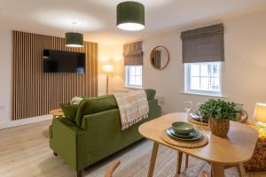 a living room with a green couch and a table at Beautiful apartment in city centre in Southampton