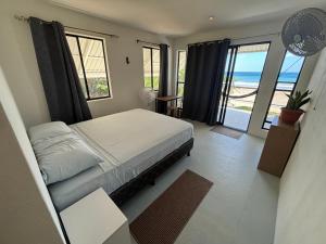 a bedroom with a bed and a view of the ocean at Stella Mar Oceanfront Hotel in Popoyo