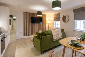 a living room with a green couch and a table at Beautiful apartment in city centre in Southampton