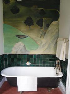 a bath tub in a bathroom with a golf mural at Stanshope Hall in Alstonfield