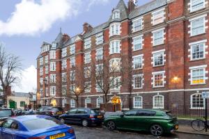 a large brick building with cars parked in front of it at The St John's Wood Apartment in London