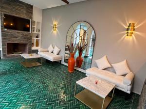 a living room with two couches and a fireplace at Riad Darchica in Marrakech