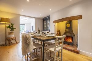 a dining room with a table and a fireplace at Owl Cottage W in Warham