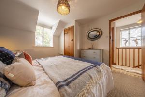 a bedroom with a bed and a mirror and a window at Owl Cottage W in Warham