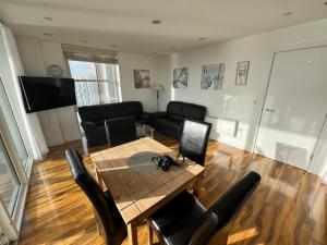 a living room with a table and chairs and a couch at Spacious 2 Bedroom Flat Stunning Waterside View in Manchester