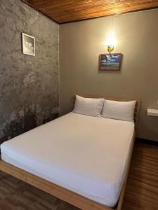 um quarto com uma cama branca num quarto em Phangnga Save House - เซฟเฮาส์พังงา em Phangnga
