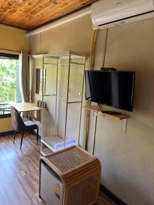 Il comprend un salon doté d'une télévision et d'une table avec une chaise. dans l'établissement Phangnga Save House - เซฟเฮาส์พังงา, à Phangnga