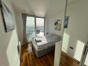 um pequeno quarto com uma cama e uma varanda em Spacious 2 Bedroom Flat Stunning Waterside View em Manchester