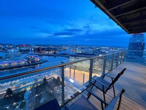 a balcony with two chairs and a view of a city at Spacious 2 Bedroom Flat Stunning Waterside View in Manchester