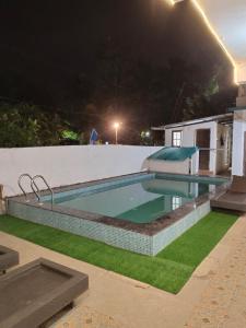 een zwembad in een achtertuin 's nachts bij Casa De Rocks in Calangute