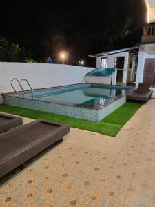 a swimming pool in a house at night at Casa De Rocks in Calangute