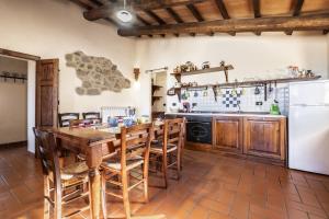 - une cuisine avec une table et des chaises en bois dans l'établissement Genziana, à Arcidosso