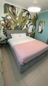 - une chambre avec un grand lit orné d'une peinture murale dans l'établissement Carmel Beach Luxury Apartment, à Haïfa