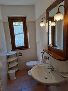 a bathroom with a sink and a toilet and a mirror at Villa Celeste in Rocca Pia