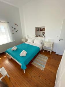 een slaapkamer met een blauw bed met 2 handdoeken erop bij Tsipouras House in Kýthira