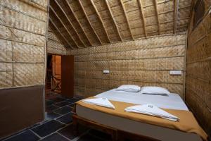 Hampi Social Resort في هامبي: غرفة نوم بسرير في غرفة خشبية