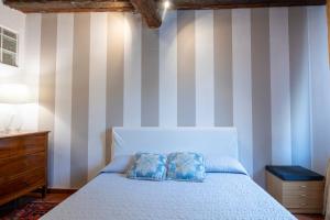 a bedroom with a bed and a striped wall at Ai piedi del castello / 4PL / Apt. FULL in Verona