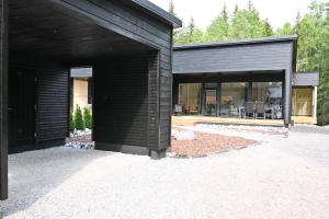 ein schwarzes Haus mit Glastüren und einer Terrasse in der Unterkunft Apartment RIVA in Turku