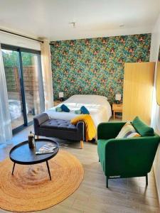 1 dormitorio con cama, sofá y mesa en Charmant studio 25 minutes de Paris avec parking en Brunoy