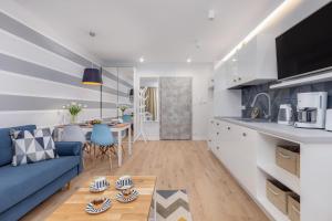 a kitchen and living room with a blue couch at Pobierowo Beach Baltic Apartments by Renters in Pobierowo