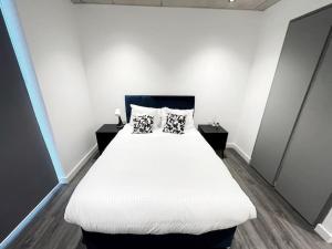 una camera da letto con un grande letto bianco con due cuscini di 2bed on Elizabeth line-5mins to Excel Custom House a Londra
