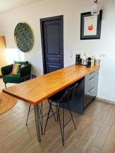 cocina con mesa de madera y 2 sillas en Charmant studio 25 minutes de Paris avec parking en Brunoy