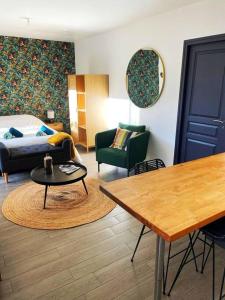 Sala de estar con cama y mesa en Charmant studio 25 minutes de Paris avec parking en Brunoy