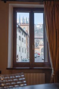 a window with a view of a city at Ai piedi del castello / 4PL / Apt. FULL in Verona