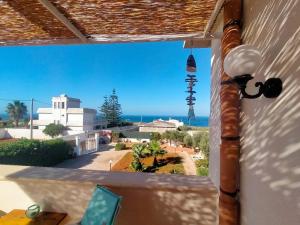 a view of the ocean from a balcony with a lighthouse at Casa&Mare Mazara del Vallo in Granitola